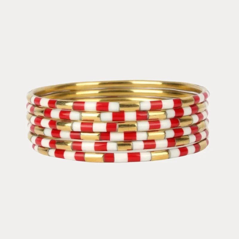 Stack of red, white, and gold bangles on a light gray background