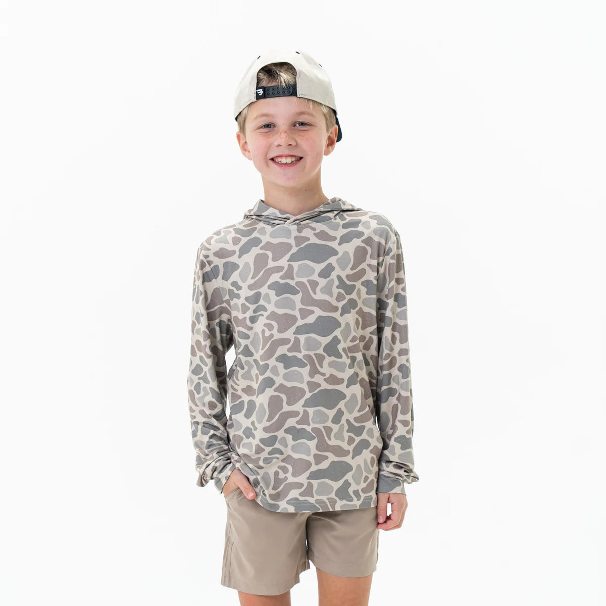 Child wearing a camouflage hoodie and beige shorts on a white background