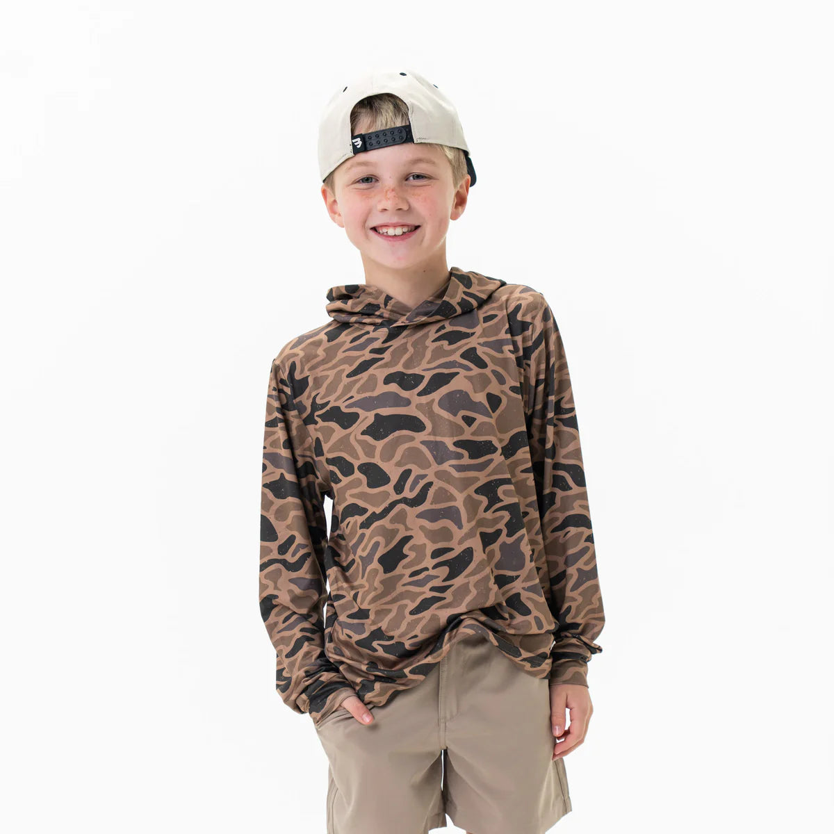 Child wearing a camouflage hoodie and beige cap on a white background