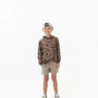 Child wearing a camouflage hoodie and beige shorts on a white background