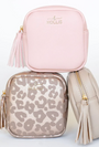 Three bags including a pink, a gold leopard print, and a beige bag with tassels on a light gray background.