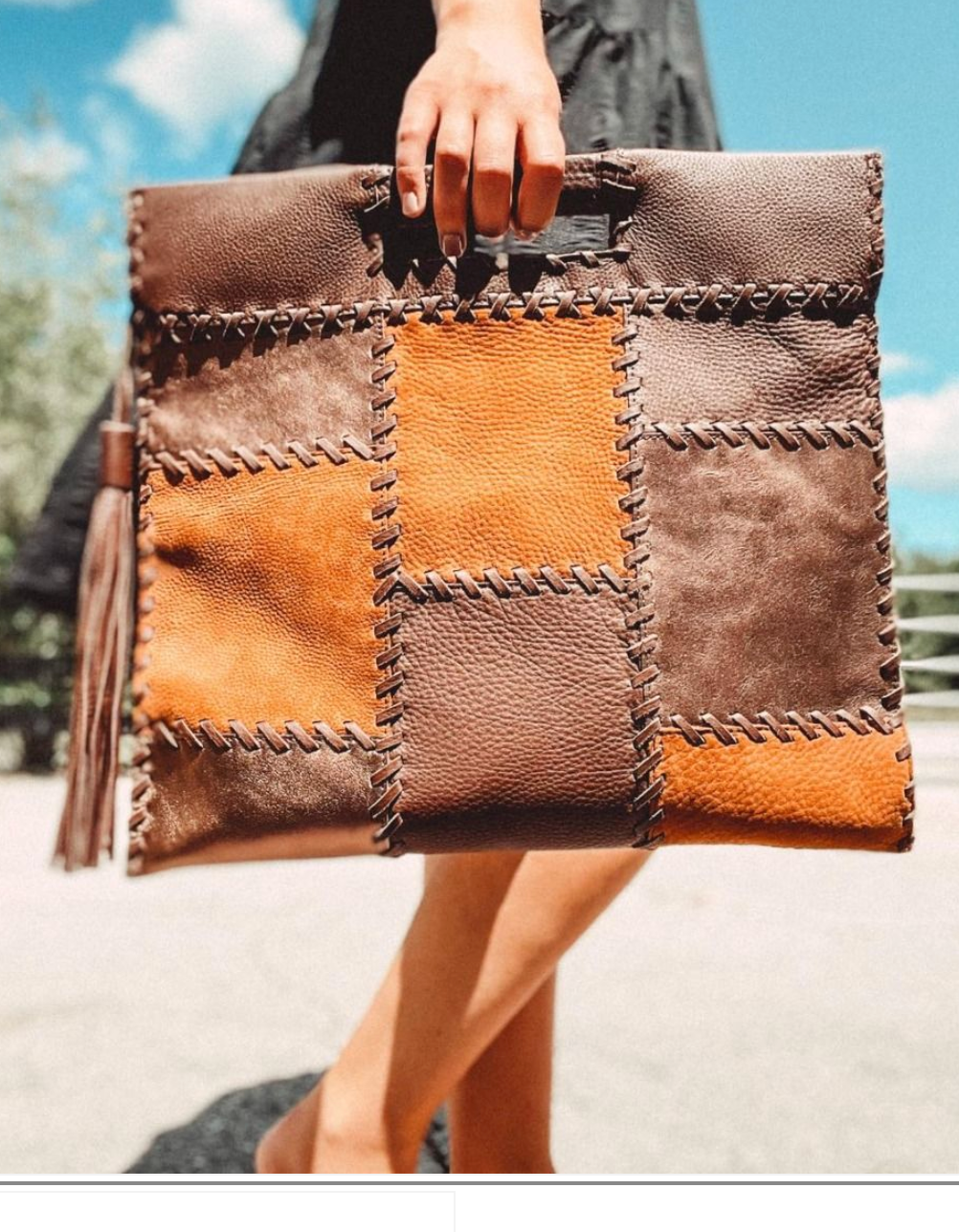 Patchwork leather clutch held by a person with a blurred background