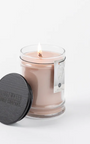 Glass candle with a label and black lid on a white background