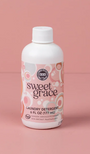 Bottle of Sweet Grace laundry detergent on a pink background