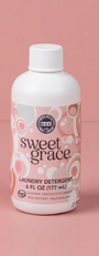 Bottle of Sweet Grace laundry detergent on a pink background