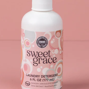 Bottle of Sweet Grace laundry detergent on a pink background