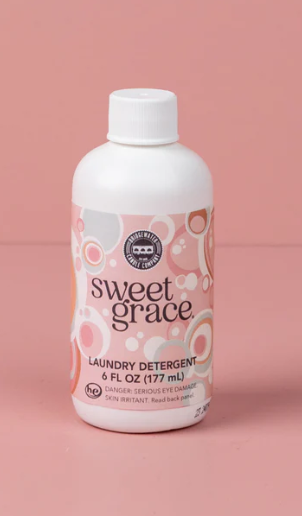Bottle of Sweet Grace laundry detergent on a pink background