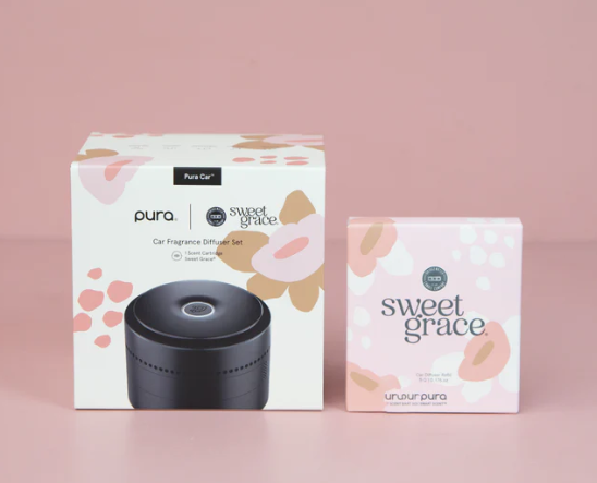 Pura car fragrance diffuser set with packaging on a pink background