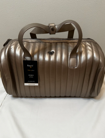 Bronze metallic duffel bag with a visible brand tag on a light background
