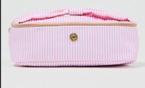 Pink striped toiletry bag with gold zipper on a light gray background
