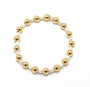 Bracelet with gold and white beads on a white background