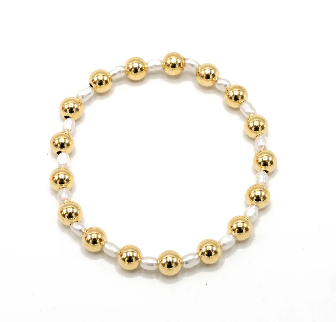 Bracelet with gold and white beads on a white background