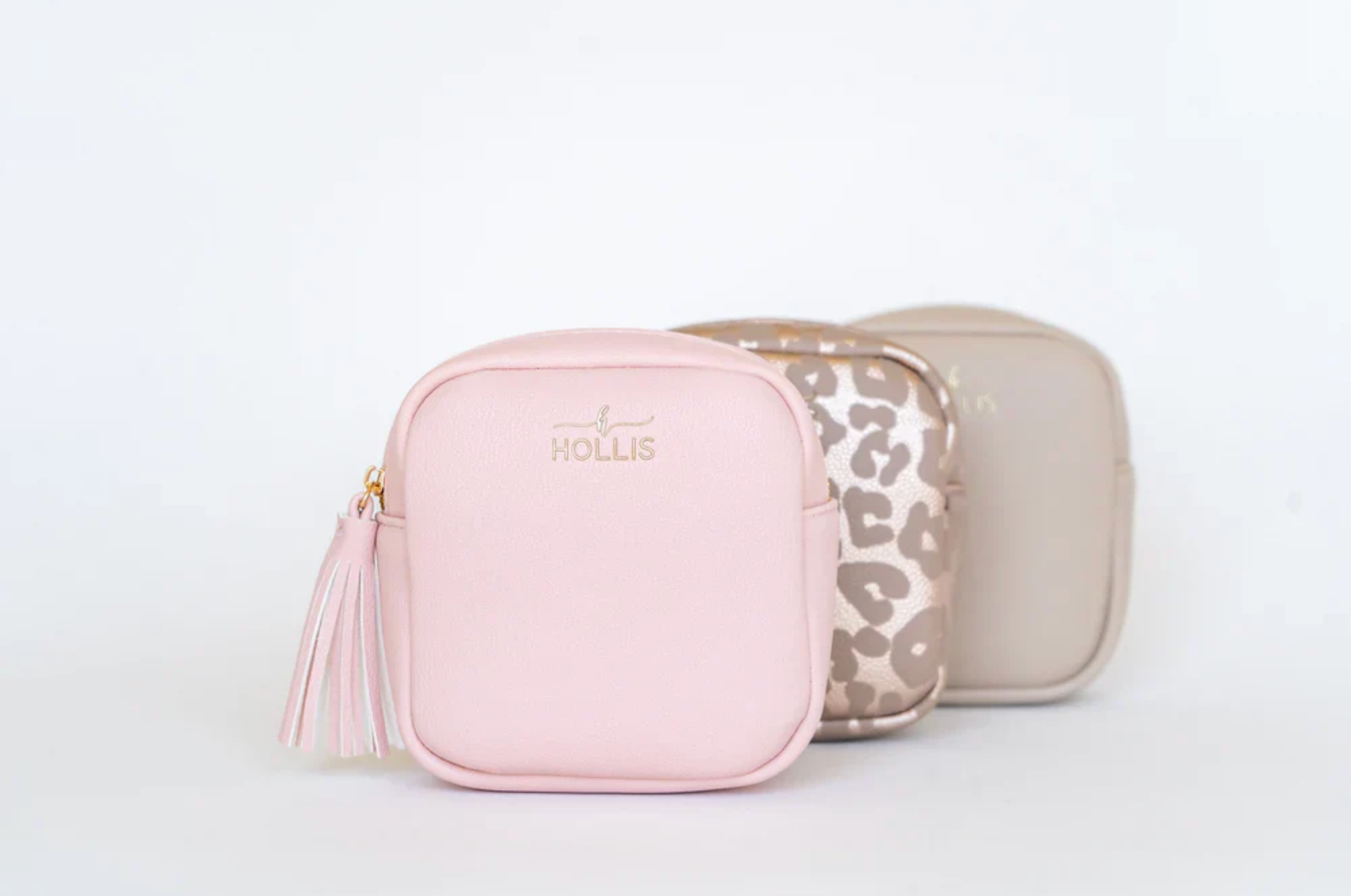Two pink and beige cosmetic bags with 'Hollie' branding on a light gray background