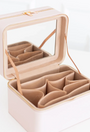 Beige jewelry case with compartments on a white background