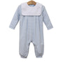 A baby long-sleeve footless romper with a white bib collar, featuring fine light blue and white stripes, hanging on a wooden hanger against a white background.