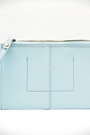 Light blue wristlet with a strap on a white background