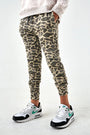 Person wearing leopard print jogger pants and Nike sneakers on a white background