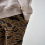 Camouflage pants worn with a gray sweatshirt on a white background