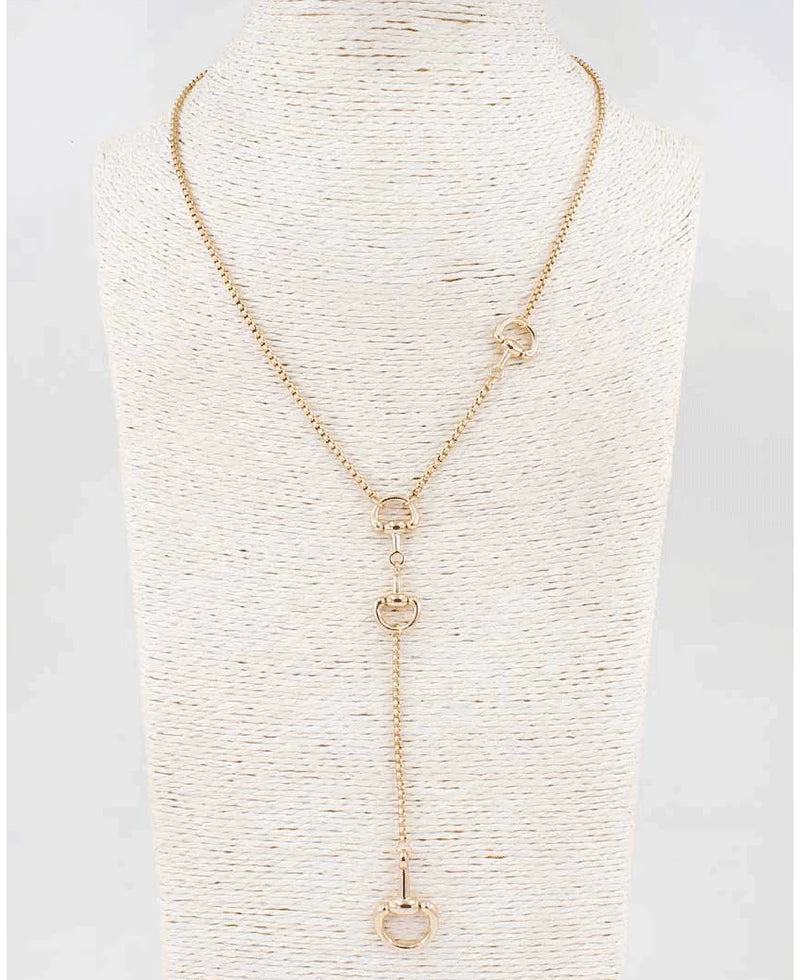 A gold-toned lariat necklace displayed on a textured cream-colored mannequin bust. The necklace features a fine chain, a central Y-shaped drop with three interlocking circular links, and two smaller circular links on the upper strap.