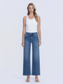 Woman wearing blue jeans and a white tank top on a white background