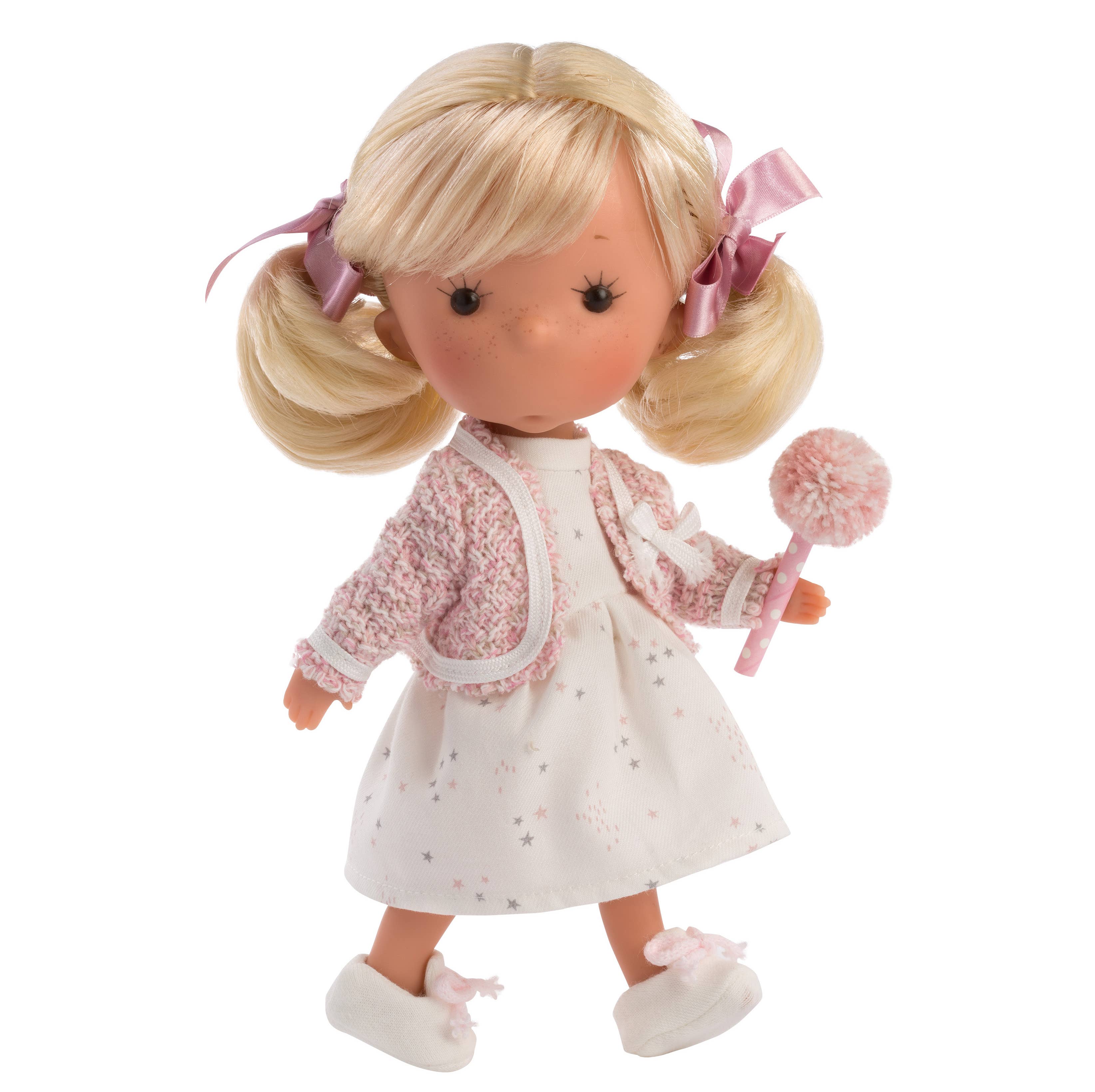 Doll with blonde hair in pigtails, wearing a white dress with pink accents and holding a pink toy.
