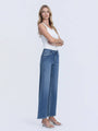 Woman wearing a white top and blue jeans on a white background