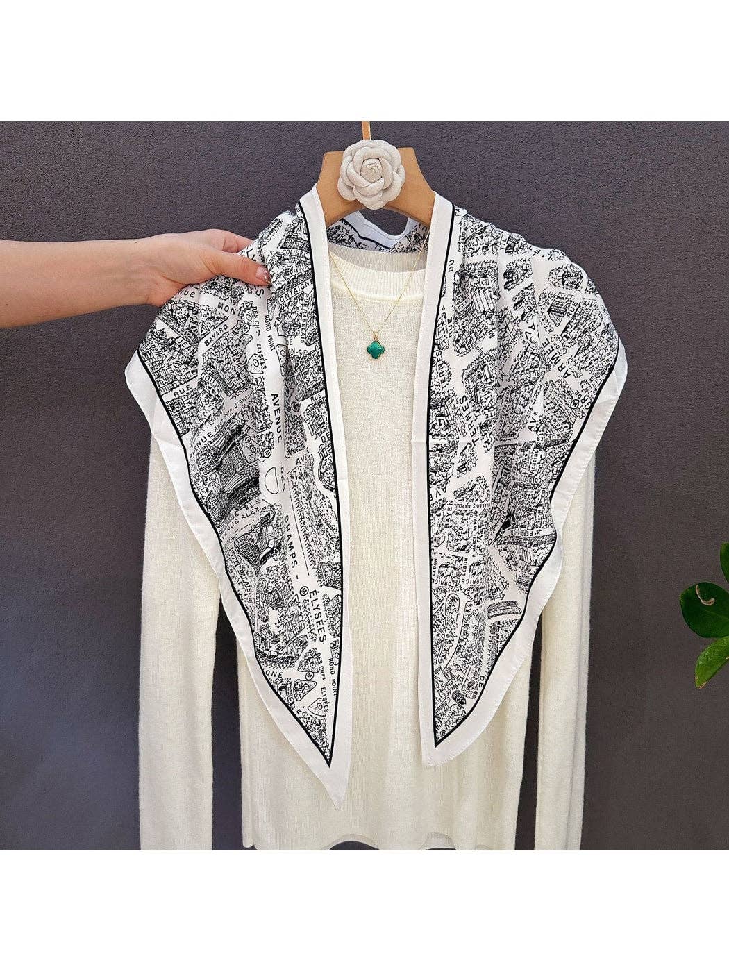Triangle scarf draped in a V shape, black and white abstract pattern