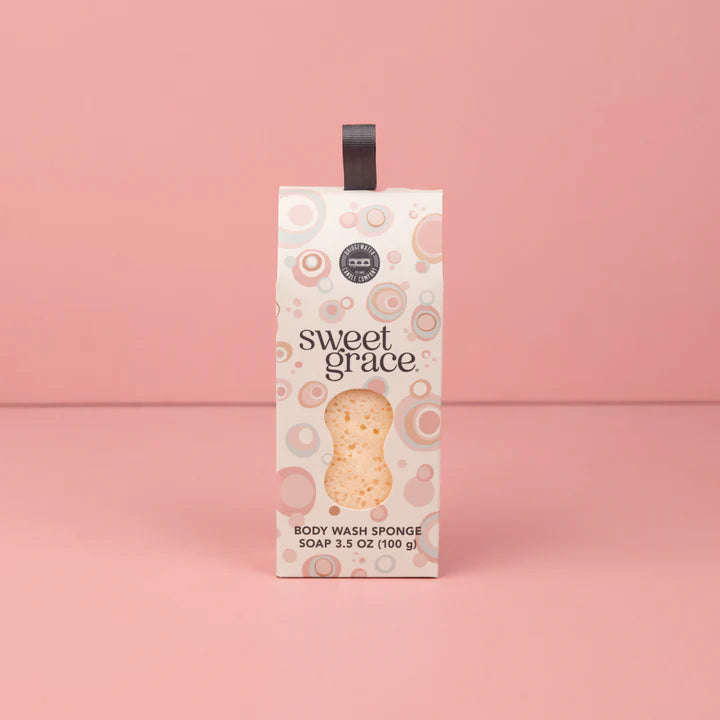 Box of 'sweet grace' body wash sponge on a pink background