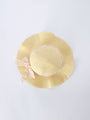 Yellow straw hat with a decorative bow on a light gray background