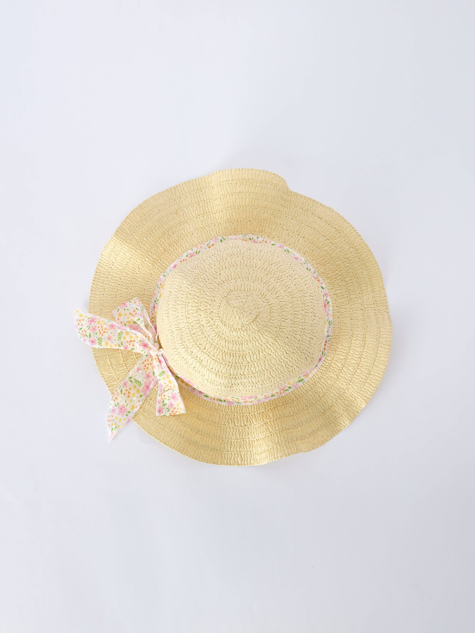 Yellow straw hat with a decorative bow on a light gray background