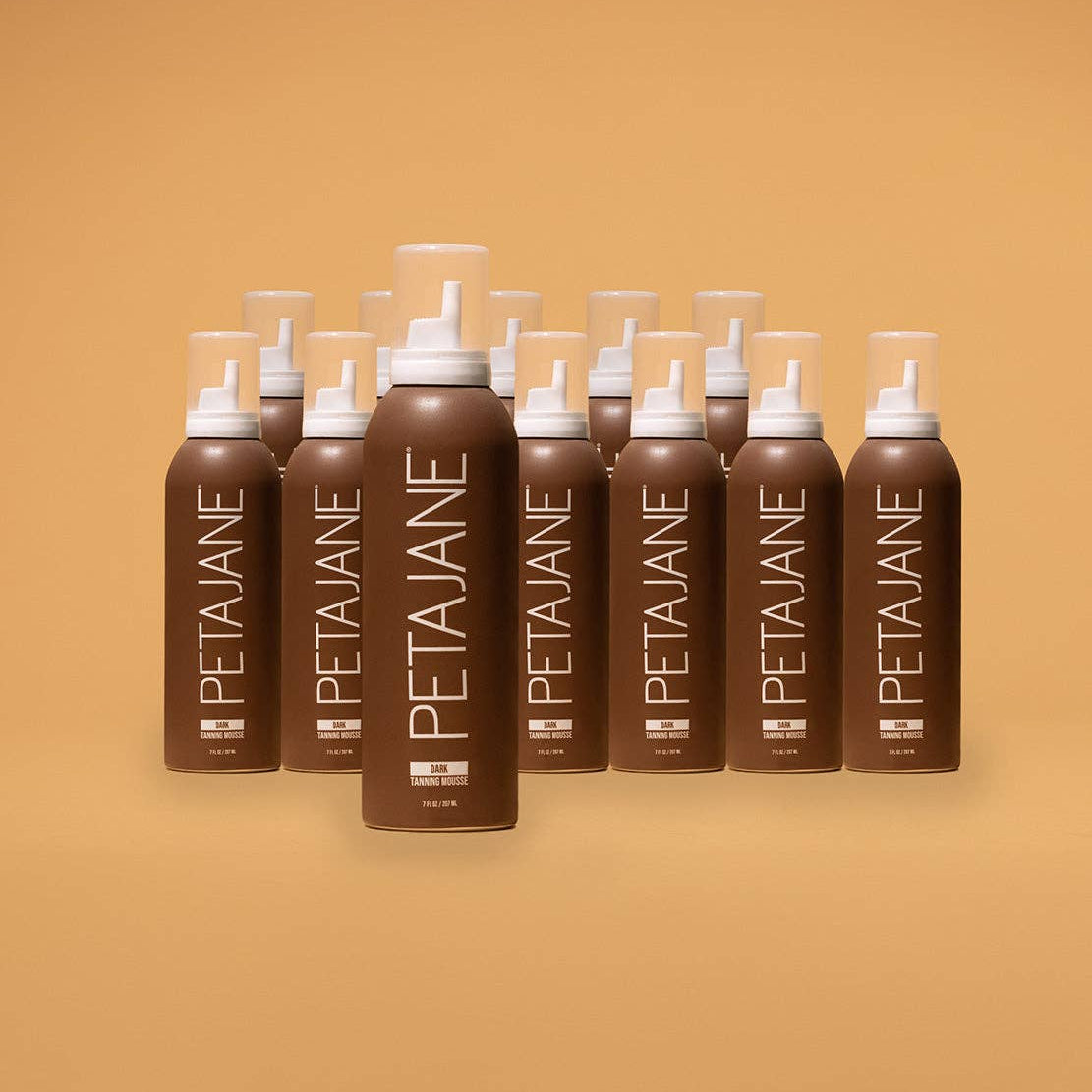 Multiple bottles of Peta Jane hair product arranged in a row on a beige background