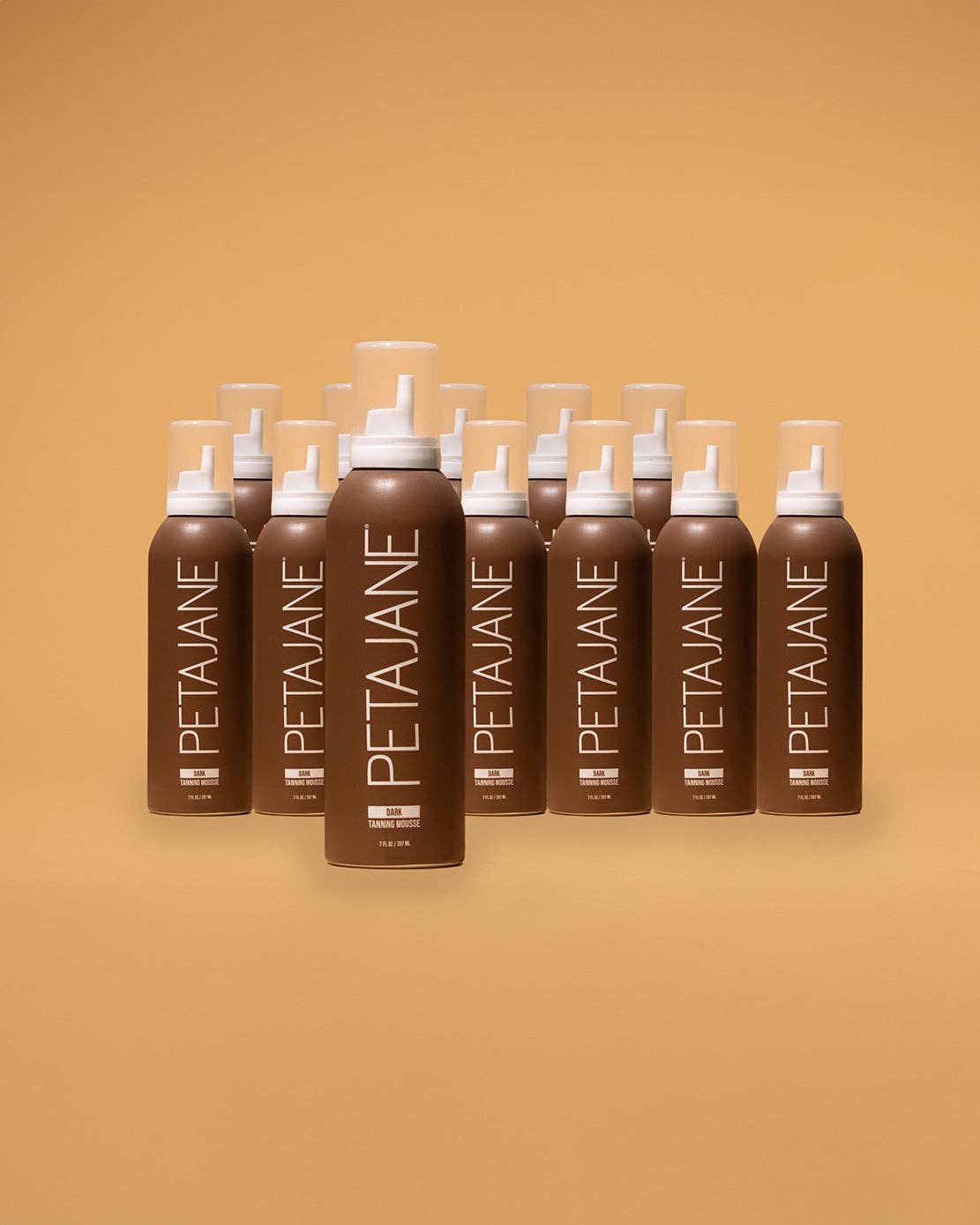 Multiple bottles of Peta Jane hair product arranged in a row on a beige background
