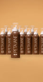 Multiple bottles of Peta Jane hair product arranged in a row on a beige background