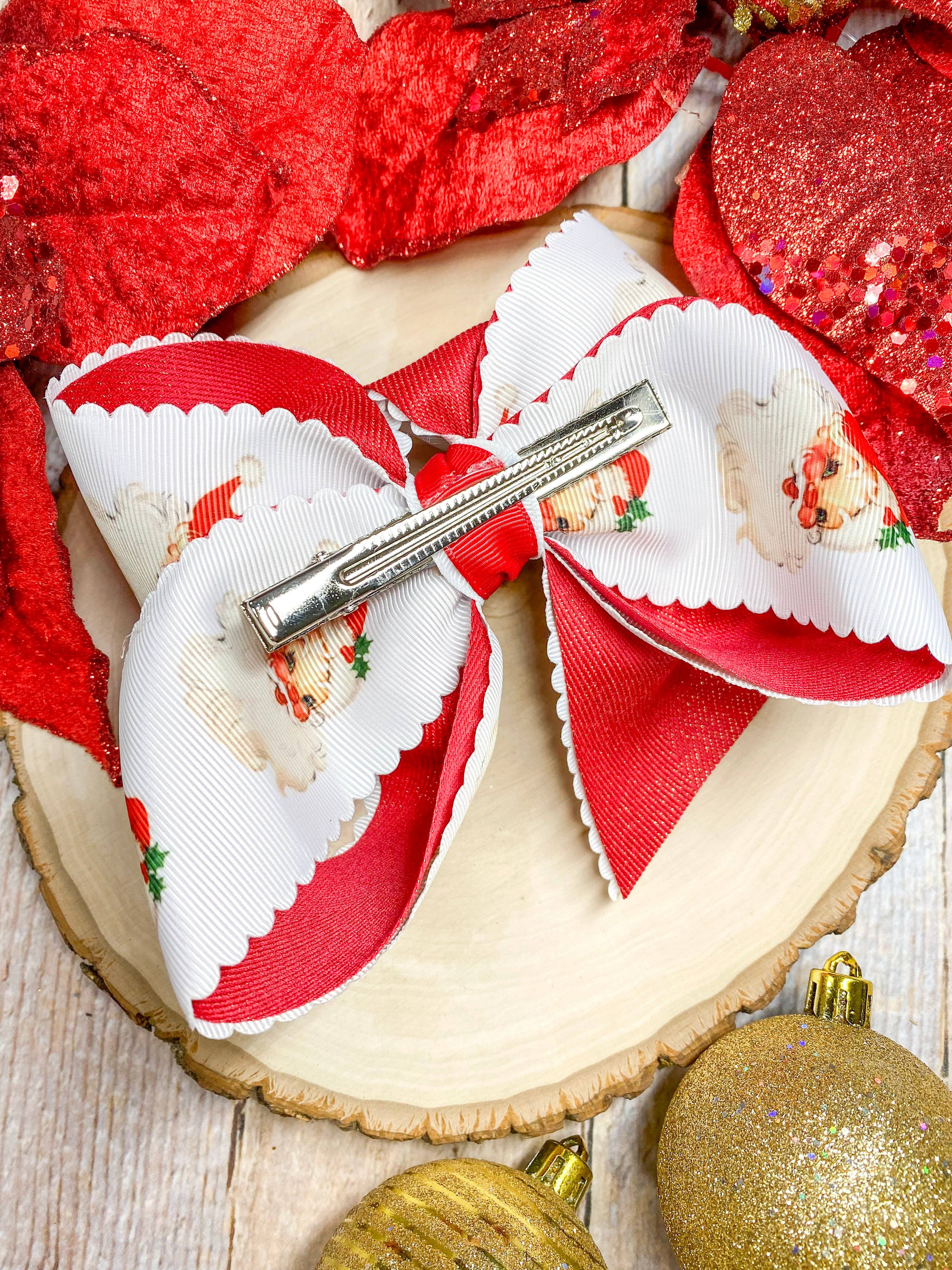 Red and white bow with a hair clip on a wooden surface with Christmas ornaments.