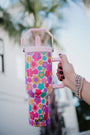 Colorful floral-patterned water bottle held by a person with blurred background