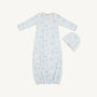 Baby gown with blue floral pattern and matching hat on a white background