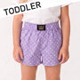 Purple polka dot shorts with a visible brand label on a white background, labeled 'TODDLER'.