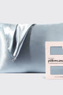 Silver satin pillowcase on a light gray background with a brand label.