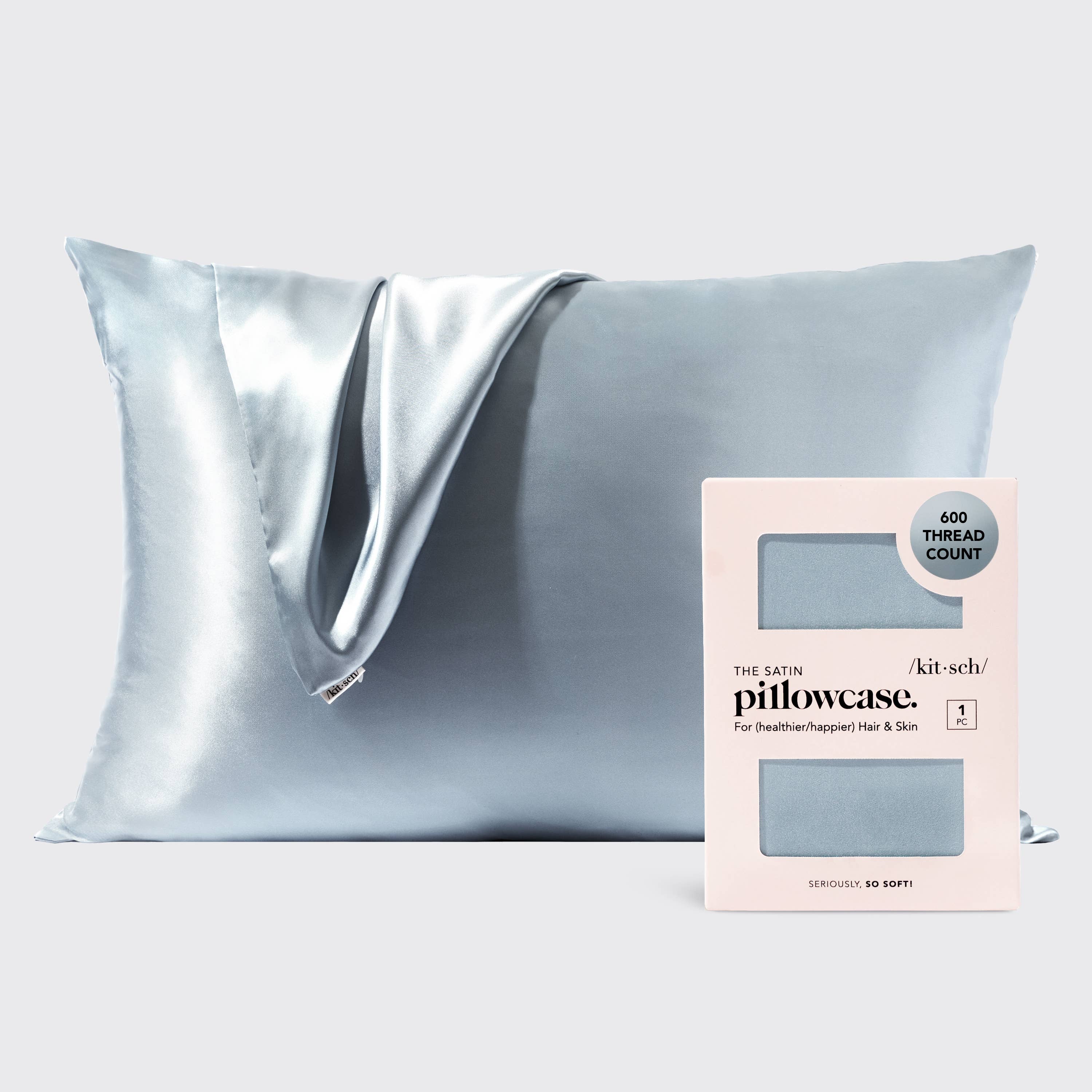 Silver satin pillowcase on a light gray background with a brand label.