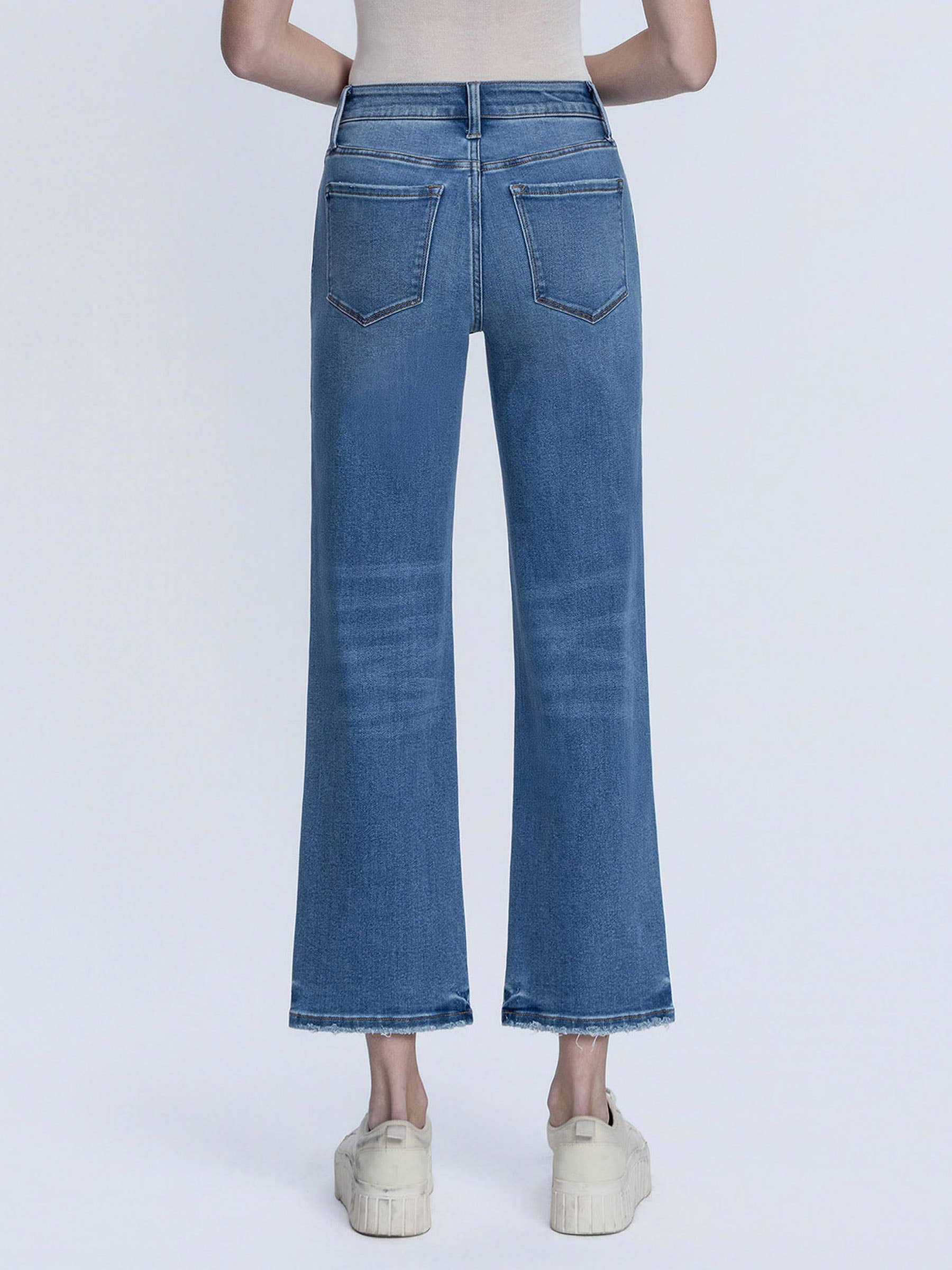 Blue jeans worn by a person on a white background