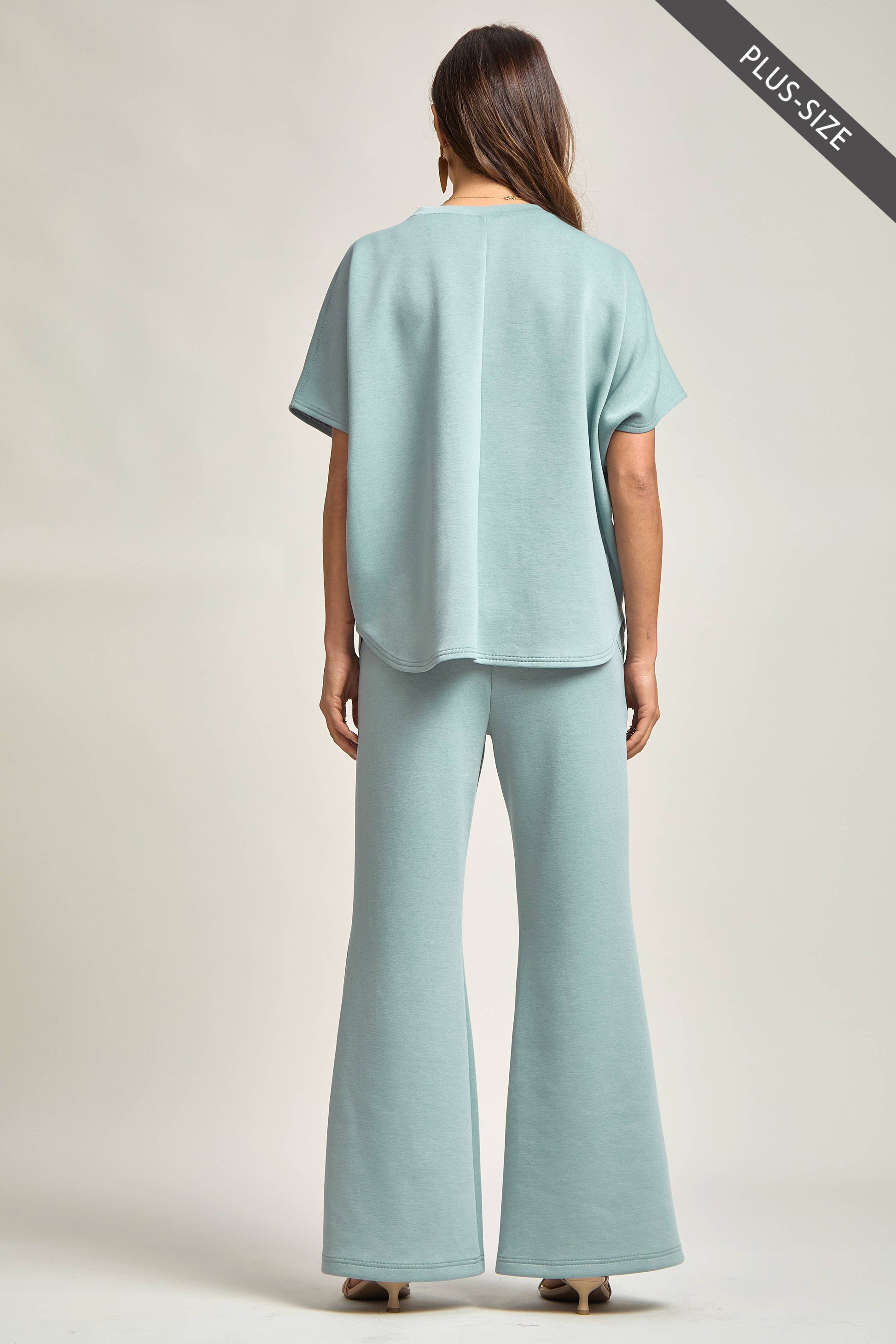 Woman wearing a light blue outfit with a plain background