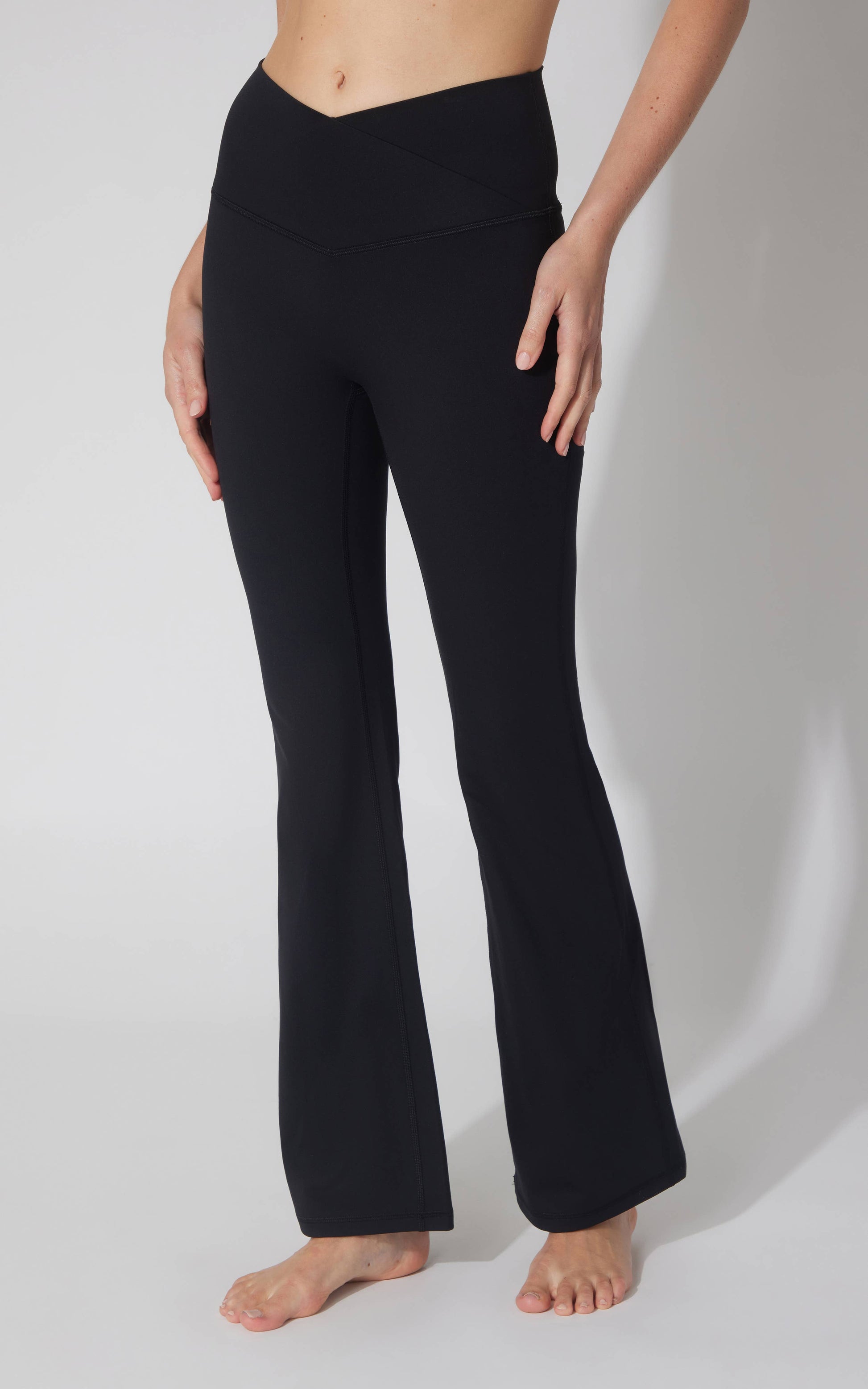 Black flared pants worn by a person on a white background