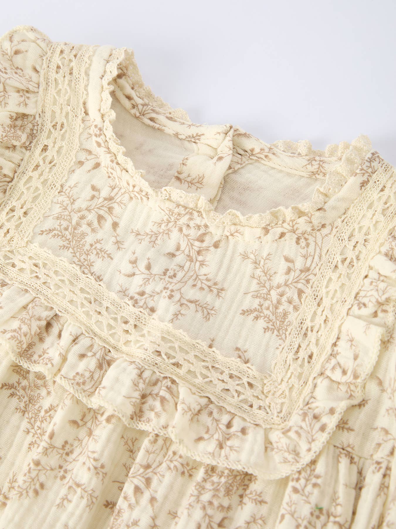 Close-up of a cream-colored lace garment on a light background