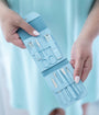 Blue nail care set in a case held by hands against a light blue background