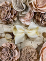 Close-up of decorative flowers and a bow on a textured surface
