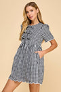 Woman wearing a black and white checkered dress on a beige background