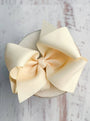 Large cream-colored bow on a wooden surface