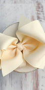 Large cream-colored bow on a wooden surface
