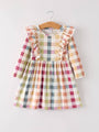 Plaid dress with ruffled sleeves on a hanger against a white background