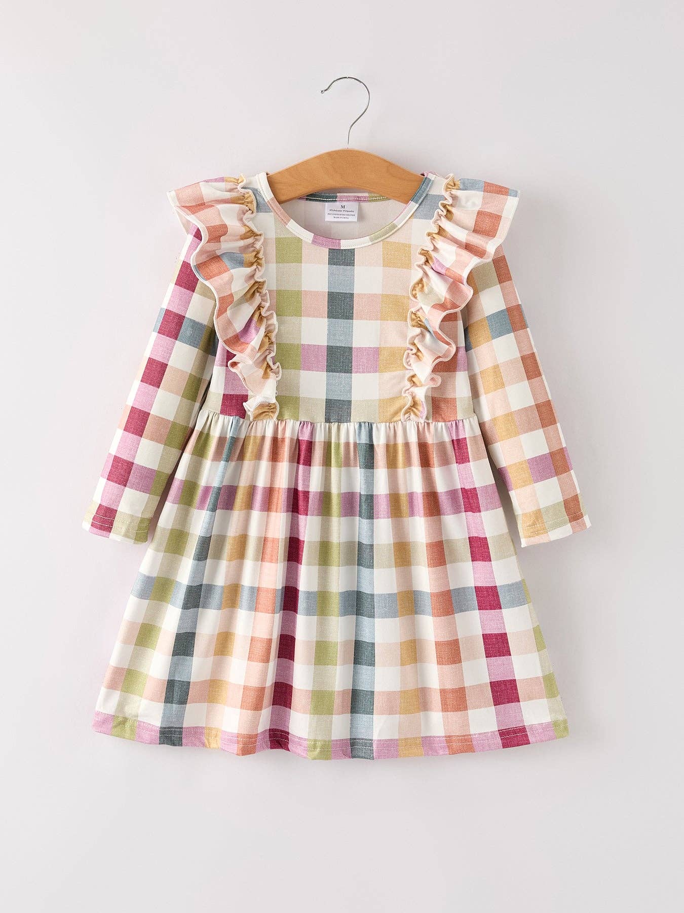 Plaid dress with ruffled sleeves on a hanger against a white background